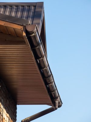 Building Modern House Construction with metal roof corner, rain gutter system and roof protection from snow board, snow bar Snow guard. Roof Snow Guards: Building Materials Supplies.